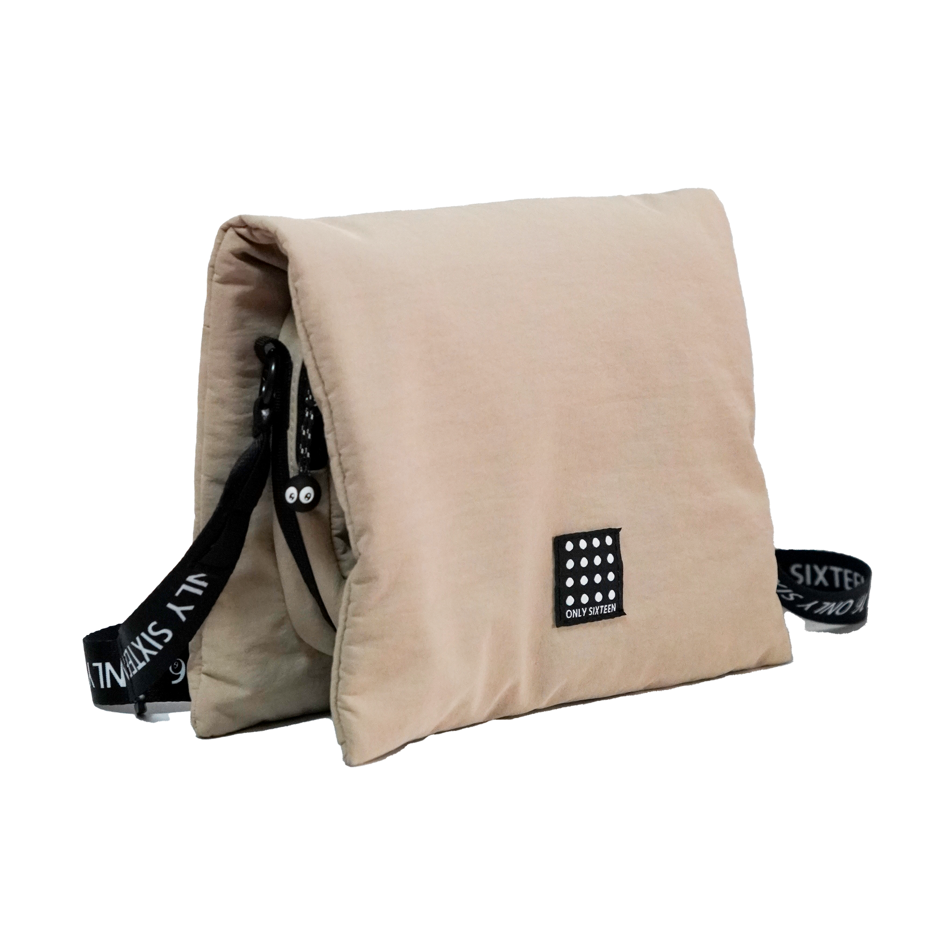 Beige pillow with black straps and branding on a white background